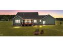 Exterior backyard showcasing a wooden deck and fire pit area for entertaining at 540 Pine Ridge Rd, Zebulon, NC 27597