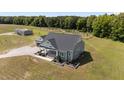 Aerial view of a charming home with gravel driveway and lush green lawn at 540 Pine Ridge Rd, Zebulon, NC 27597