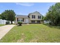 Traditional home with a manicured lawn, a dark roof, and classic beige siding at 5529 Wood Pond Ct, Raleigh, NC 27610