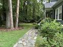 Stone pathway leading up to the home, featuring lush greenery and mature trees for a serene setting at 5816 Henner Pl, Durham, NC 27713