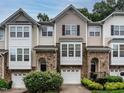 Charming townhome exteriors boast stone accents, neutral siding, attached garages, and manicured shrubs at 6206 Braidwood Court Ct, Raleigh, NC 27612