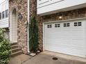 Attached garage door with stone surround and side door for an inviting entrance at 6206 Braidwood Court Ct, Raleigh, NC 27612