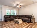Spacious living room featuring a large sectional sofa, ceiling fan, and natural light at 6206 Braidwood Court Ct, Raleigh, NC 27612