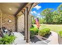 Inviting front porch with stone accents, an American flag, and comfortable seating at 7552 Hasentree Club Dr, Wake Forest, NC 27587