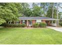 Charming single-story brick home with well-maintained landscaping and a convenient attached carport at 780 Leslie Campbell Ave, Lillington, NC 27546