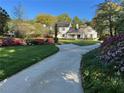 Stunning home with meticulous landscaping, a winding driveway, and beautiful flowering bushes at 1004 E Willowbrook Dr, Burlington, NC 27215