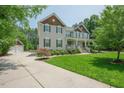 Well-maintained home with a manicured lawn, complemented by an oversized driveway leading to a detached garage at 1005 Hidden River Ct, Raleigh, NC 27614