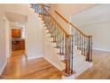 Elegant staircase showcasing detailed ironwork and hardwood flooring, leading to the upper level at 1005 Hidden River Ct, Raleigh, NC 27614