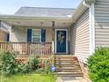 Cozy porch with a decorative front door, plants, and seating at 101 Langston Ridge Dr, Angier, NC 27501