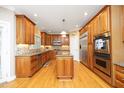 Spacious kitchen features wood cabinets, stainless steel appliances, granite countertops, and a central island at 101 Royal Glen Dr, Cary, NC 27518