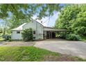 Home exterior with covered patio and carport, complemented by lush landscaping and a driveway at 1090 S Fifth St, Mebane, NC 27302