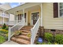Inviting front porch with brick steps, white railings, and colorful flower accents at 121 Fort Jackson Rd, Morrisville, NC 27560