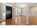 Open entryway featuring hardwood floors, white pillars, large windows, and natural light at 1211 E Pointe Dr, Durham, NC 27712