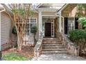 Inviting front porch with stone steps and accents and a dark wood front door at 1211 E Pointe Dr, Durham, NC 27712