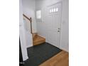 Bright entryway featuring a white door, staircase, and a combination of tile and wood flooring at 1402 Barton Place Dr, Raleigh, NC 27608