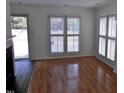 Bright living room with hardwood floors, shutters, and a view to an outdoor entrance at 1402 Barton Place Dr, Raleigh, NC 27608