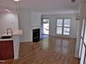 Open living room with hardwood floors, fireplace, and natural light from multiple windows at 1402 Barton Place Dr, Raleigh, NC 27608
