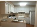 Bright kitchen featuring white cabinetry, modern appliances, and a breakfast bar for casual dining at 1913 Rendall St, Burlington, NC 27215