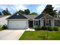 Single-story home featuring attached garage, light gray siding, black shutters, and well-kept lawn at 2039 Alderman Way, Creedmoor, NC 27522