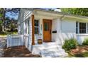 Charming front porch with wooden door and white painted brick at 207 N Aiken St, Fuquay Varina, NC 27526