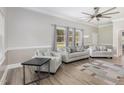 Bright living room features modern furniture, stylish decor, large windows, and a ceiling fan for added comfort at 208 S College Ave, Kenly, NC 27542