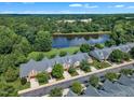 Scenic aerial view showcasing townhomes surrounded by a lush green landscape and a peaceful lake at 240 Meadow Beauty Dr, Apex, NC 27539