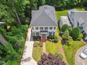 An aerial view of a two-story home featuring manicured landscaping, black shutters, and mature trees at 2725 Rosedale Ave, Raleigh, NC 27607