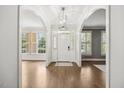 Bright foyer featuring hardwood floors, arched doorways, natural light, and a modern chandelier at 2725 Rosedale Ave, Raleigh, NC 27607