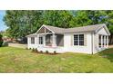 Angle view of a charming one-story home with a landscaped front yard and beautiful curb appeal at 309 S Mckay Ave, Dunn, NC 28334