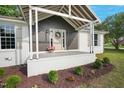 Inviting front porch with decorative wreath, stone accents, and a pot of flowers at 309 S Mckay Ave, Dunn, NC 28334
