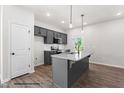 Modern kitchen with stainless steel appliances, gray cabinets, granite countertops and island at 325 Bluejay St, Clayton, NC 27520