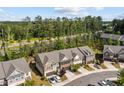 Aerial view of townhomes with tree lined roads and surrounding lush landscape at 329 Castle Rock Ln, Cary, NC 27519