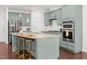 Bright kitchen features granite countertops, stainless steel appliances, eat at island, and wood floors at 329 Castle Rock Ln, Cary, NC 27519