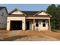 New construction featuring a covered porch and an attached garage with unfinished siding at 335 Bluejay St, Clayton, NC 27520