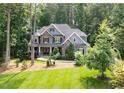Attractive two-story home featuring stone accents, manicured lawn, and mature trees at 3587 Garner Terrace Way, Wake Forest, NC 27587
