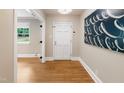 Warm, inviting foyer featuring gleaming hardwood floors and a modern art piece at 3934 Hope Valley Rd, Durham, NC 27707