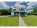 Beautiful home with blue brick exterior, complemented by lush green lawn and bright blue skies at 408 N Maple St, Graham, NC 27253
