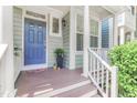 Inviting front porch with a blue door, white columns, and decorative plants at 412 Heritage Village Ln, Apex, NC 27502
