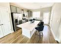 Modern kitchen featuring stainless steel appliances, light gray cabinetry, and an island with seating at 503 Gateway Townes Blvd, Wake Forest, NC 27587