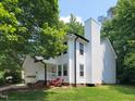 Charming two-story home with white siding, black trim, a chimney, and a lush green lawn at 5105 Carolwood Ln, Durham, NC 27713