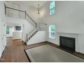 Bright living room features a fireplace, hardwood floors, and a staircase leading to the second floor at 5105 Carolwood Ln, Durham, NC 27713