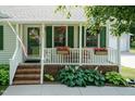 Inviting front porch decorated with flowers, offering a cozy space to enjoy the outdoors at 523 Edwards Rd, Henderson, NC 27537