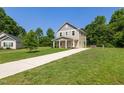 Charming two-story home with covered porch and long driveway on a spacious lawn at 567 E Ridge Ave, Liberty, NC 27298