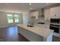 This modern kitchen is designed with a large island, stainless steel appliances, and sleek white cabinets at 659 Bandon Aly, Cary, NC 27513
