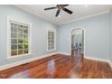 Bright bedroom with hardwood floors, ceiling fan, and natural light from large windows at 7604 Copper Creek Ct, Wake Forest, NC 27587