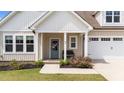 Charming covered front porch featuring a cozy bench and a vibrant floral wreath on the front door at 80 Shallow Falls Ln, Benson, NC 27504