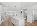 Open-concept kitchen with white cabinetry, quartz island, stainless appliances, and seamless flow into the spacious living area at 800 Hillfarm Dr, Wake Forest, NC 27587