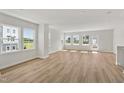 Bright living room featuring gleaming hardwood floors, multiple windows offering abundant natural light, and neutral paint at 800 Hillfarm Dr, Wake Forest, NC 27587