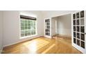 Sunlit living room featuring hardwood floors and decorative glass doors at 803 High Ct, Hillsborough, NC 27278