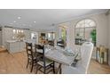 Open-concept dining room featuring a glass-top dining table, seating for six, and hardwood floors at 814 Covered Bridge Trl, Chapel Hill, NC 27517